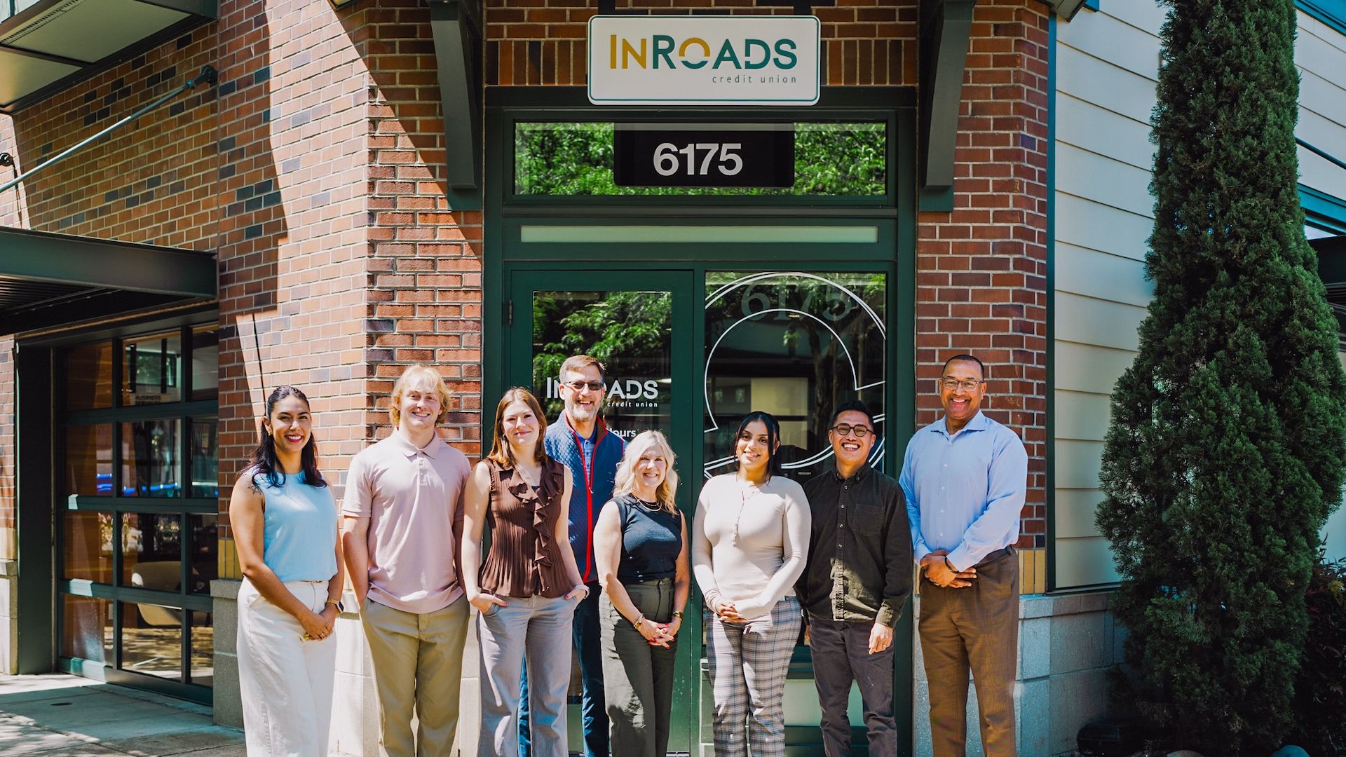 Pacific students and employees pose in front of a local business