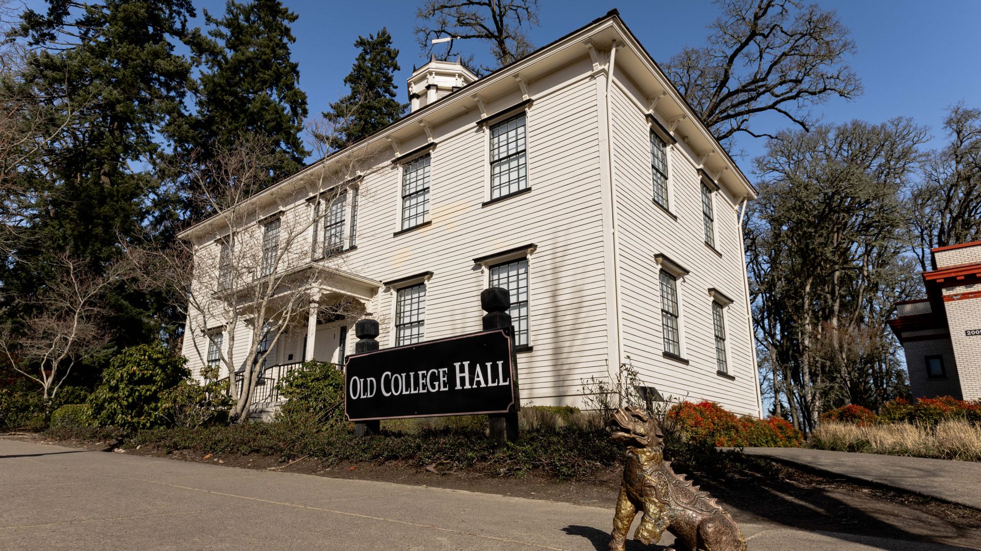 A picture of Old College Hall taken by Kent J Edwards featuring the original Boxer statue on the ground in front of the building.