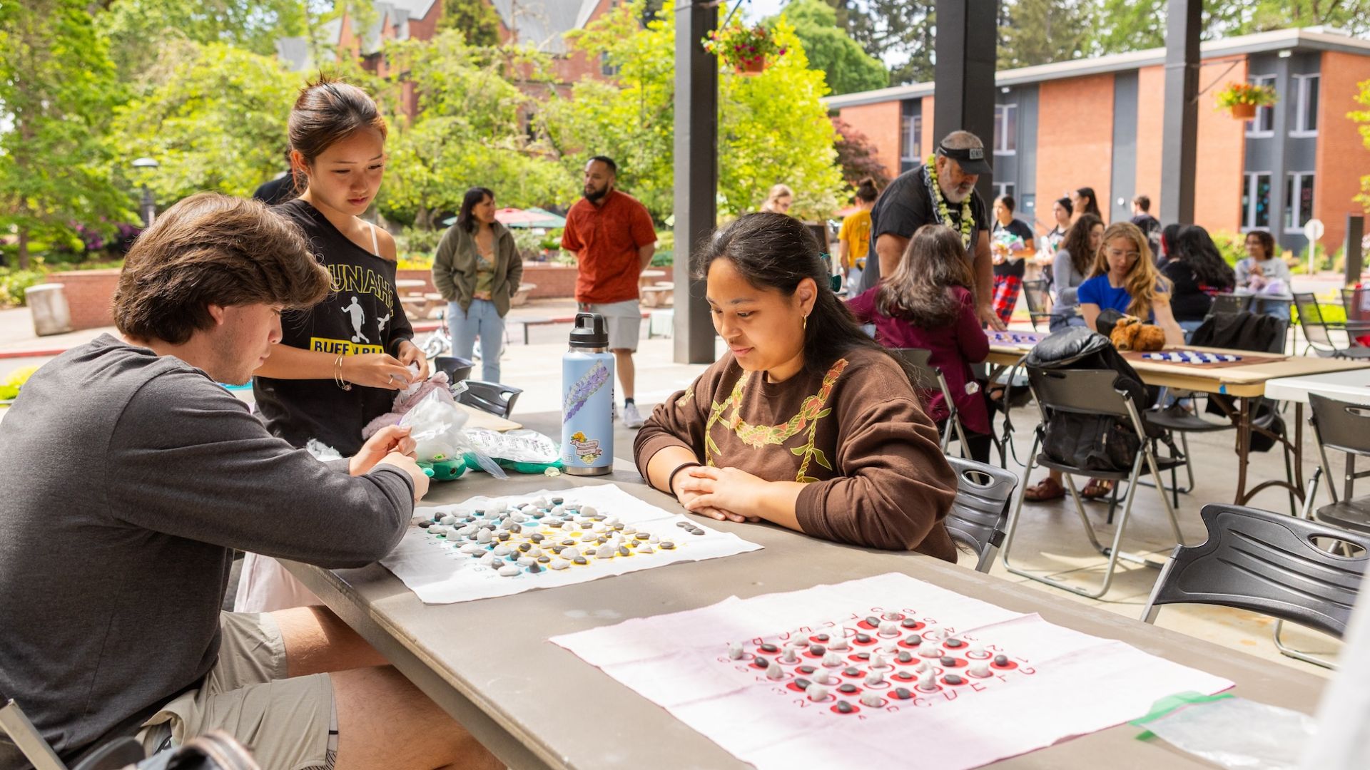 Pacific students play a board game on campus