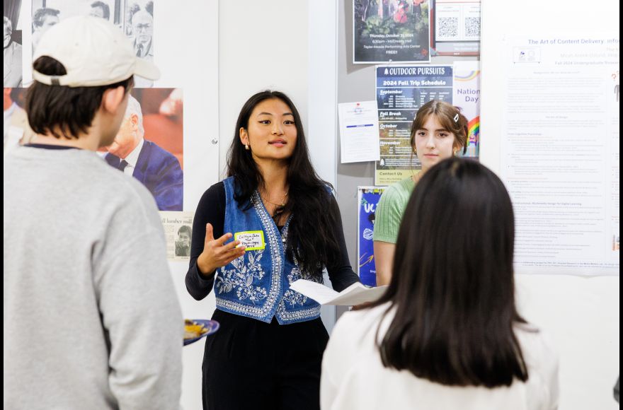 Two Pacific students present a research poster to fellow students